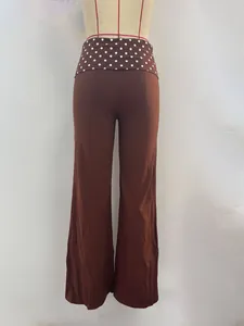 Detail of high waisted dark brown trousers featuring a white polka dot belt decoration