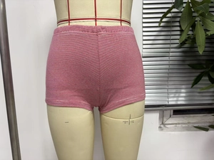 Detail of red and white striped tight shorts featuring elastic waist on a mannequin