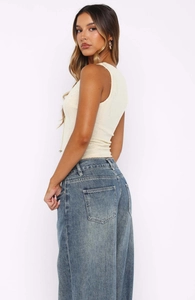 Détail de la texture du débardeur gaufré ivoire avec un jean en denim délavé rétro
