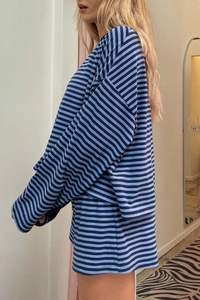 Side view of oversized blue and black striped long sleeve top and shorts two-piece set