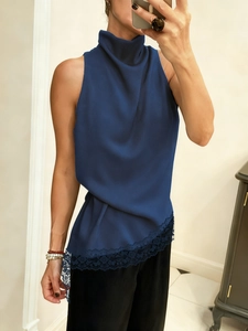 Detail view of navy blue halter top featuring delicate lace trim and asymmetrical hem texture