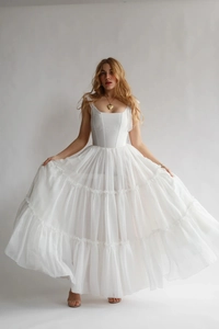 Détail d'une robe maxi blanche à volants avec de fines bretelles et des couches de mousseline