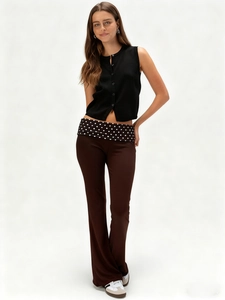 Casual women's solid knit vest and dark brown flared trousers with polka dot waist