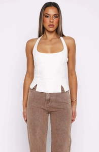 Detail view of white halter top featuring side zippers and symmetrical hem slits