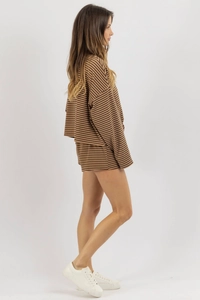 Side view of woman in brown striped knit lounge set with oversized top and shorts