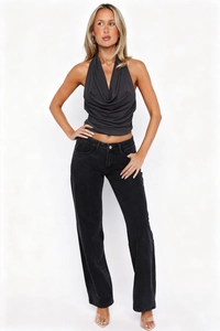 Detail of dark grey halter top with draped neck paired with high waist black jeans
