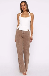 Detail view of a white halter crop top featuring a unique side slit hem and slim fit