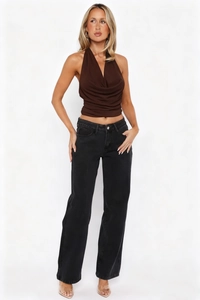 Detail of a dark brown halter neck crop top paired with classic black denim jeans