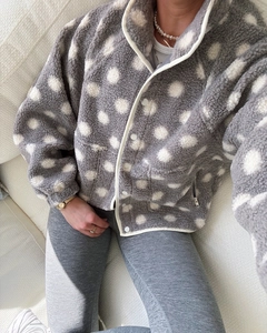Close-up of soft grey fleece jacket with large white polka dots and white snap buttons