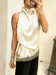 Detail of elegant beige satin halter top with delicate brown lace trim hemline