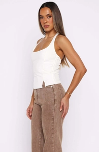 Close-up of white halter top featuring a discreet side zipper and ribbed knit texture