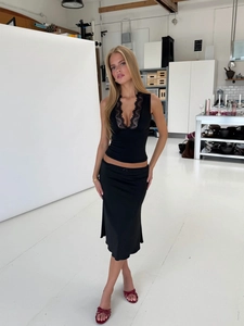 Detailansicht eines schwarzen schmalen Tanktops mit Spitzenbesatz und seidigem Rock-Set