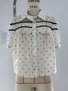 Détail de chemise blanche à cœurs avec rubans noirs et boutons ronds transparents