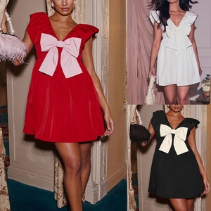 Detail of V-neck party mini dress featuring a large bow and elegant ruffled sleeves