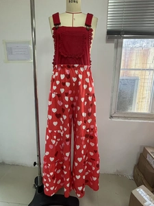 Detail eines roten Overalls mit Herzprint am weiten Bein und gerüschter Brusttasche