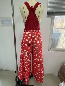 Detailansicht der Rückseite eines roten Spitzen-Tops und einer Herz-Print-Hose mit weitem Bein