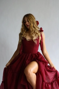 Détail d'une robe maxi corset rouge à bretelles et ourlet à volants avec fente latérale