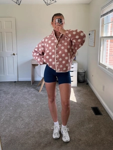 Chic pink fleece jacket with white polka dots featuring stand collar and button closure