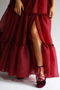 Détail de la robe en mousseline bordeaux à fente haute et chaussures en velours à nœud