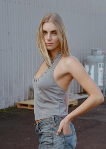 Detail of grey halter top featuring a deep U-neckline with decorative metal eyelet rings