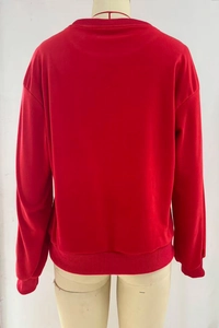 Detail view of the ribbed cuffs and hem on this loose red crewneck sweatshirt