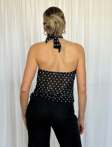 Back view of a polka dot halter top showing the tie-neck detail and open back design