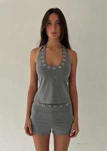Detailed view of silver metal eyelets on a grey halter neck top and matching shorts set