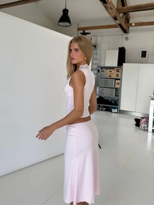 Detailansicht der eleganten weißen Spitzenborte am Ausschnitt des rosa figurbetonten Tops