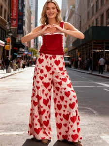 Damen-Mode-Set mit roter Rüschenweste und weiter Hose mit Herzprint in urbaner Straßenszene