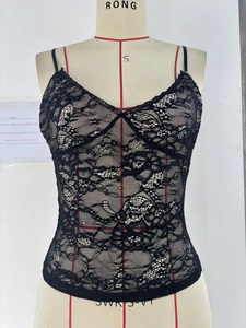 Close-up of the delicate floral lace texture and intricate hem detail on this black camisole