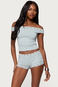 Detail view of the metal eyelet decorations on grey off-shoulder top and shorts set
