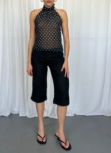 Polka dot halter top paired with black cropped trousers showing fabric texture detail