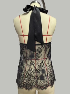 Detail of back view halter lace top featuring a large satin bow and eyelash lace hem