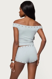 Close-up of grey off-shoulder crop top and shorts set with metallic rivet trim details