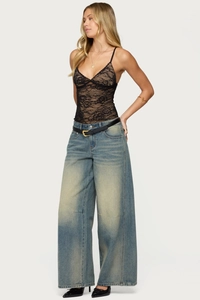 Detailed view of black floral lace camisole with sheer fabric and scalloped edge