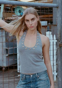 Detail of grey halter top with large metallic eyelets and industrial street style aesthetic