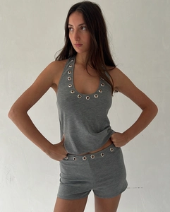 Detailed view of grey knitted set featuring halter top with metal eyelet decorations