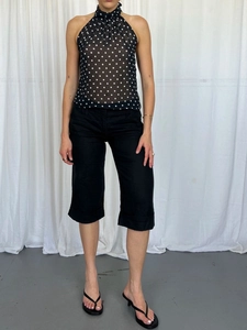 Women's summer polka dot halter top with black cropped trousers and strappy sandals
