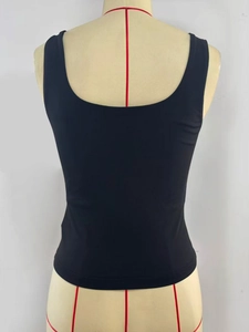 Detail des hochelastischen schwarzen Slim-Fit-Tops mit U-Ausschnitt und Metallnieten-Design