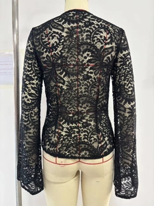 Detailed view of black floral lace fabric with intricate hollow-out embroidery on top