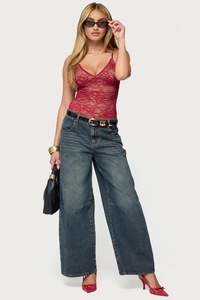 Detailed look at the red lace sleeveless top styled with high-waisted denim jeans