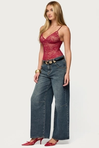 Detail of burgundy lace bodysuit with deep V-neck and high waist wide leg blue jeans
