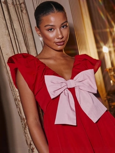Elegant V-neck dress in red and pink with a large bow detail and pleated taffeta texture