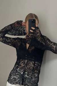 Detailed view of sheer floral lace fabric with elegant flared sleeves and button-down front