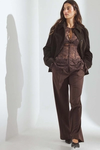 Detailed view of women's lace crochet sheer shirt and brown corduroy cropped jacket outfit
