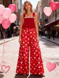 Detail des roten Spitzen-Ausschnitts und weißen Herz-Prints am Jumpsuit mit weitem Bein