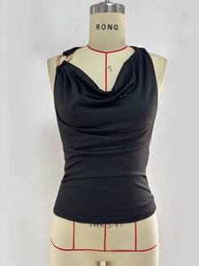 Detail of the black cowl neck top featuring a golden metal ring on the shoulder
