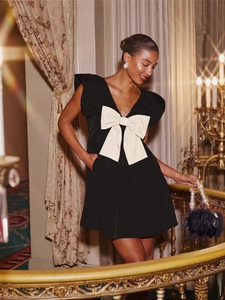 Elegant black V-neck mini party dress with a large white bow and ruffle shoulders
