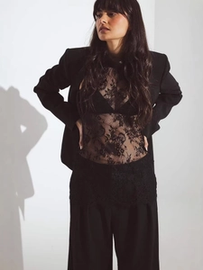 Chic black lace halter top styled with a tailored blazer and wide-leg trousers