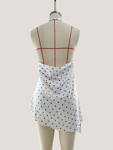 Detailed back view of sleeveless polka dot halter top with irregular hemline on mannequin